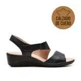 Sandalias de cuero negro con plataforma baja y ajuste con velcro en el tobillo.