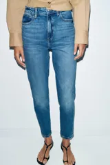 Jeans de tiro alto con corte mom fit, diseño de cinco bolsillos y raya planchada frontal. Presenta cierre frontal con cremallera y botón.