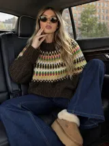 Sweater de lana merino con estampado Fair Isle en tonos azul marino, beige, naranja, verde oliva y bordó. Tiene cuello redondo y mangas largas.