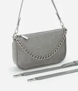 Cartera tipo baguette color gris, confeccionada en poliuretano con acabado mate. Presenta un diseño minimalista con cierre superior por cremallera, una cadena decorativa plateada en el frente y una correa larga ajustable y desmontable.