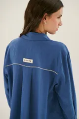 Sobrecamisa azul de lino con cuello camisero, manga larga y cierre frontal con botones.