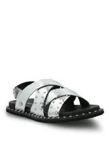 Sandalias de cuero plateado con textura de reptil, diseño de tiras cruzadas decoradas con tachas metálicas. Poseen ajuste mediante hebilla lateral y suela de goma con detalle de tachas en el borde.