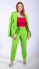 Blazer cruzado de color naranja vibrante, con solapas anchas y botones plateados. Presenta un cinturón a juego que ajusta la cintura y bolsillos frontales con solapa.
