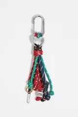 Llavero de cordones coloridos con mosquetón metálico y dije de corazón plateado.