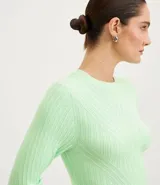 Blusa de punto color fucsia, con cuello redondo y manga larga.