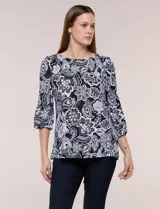 Blusa de manga tres cuartos abullonada, con escote bote y estampado floral en tonos negros y blancos.