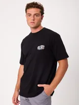 Remera negra de ajuste holgado con gran estampado gráfico en la espalda de temática tropical con una playa, palmeras y la inscripción "Welcome to Surfers Paradise".
