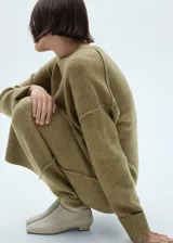 Vestido largo de punto con diseño recto, cuello redondo y manga larga con puños en canalé. Presenta una textura suave y un corte holgado.