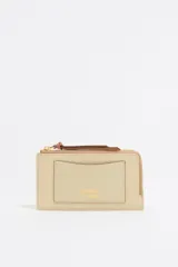 Monedero de piel vacuna con estructura rígida, cierre de cremallera con tirador de cordón y logo metálico grabado en el frente. Incluye tarjetero interior y acabados metálicos dorados.