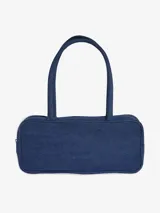 Bolso de hombro tipo cartera confeccionado en denim azul, con diseño rectangular, cierre superior y asas largas. Presenta el logo del Trifolio metálico en la parte frontal.