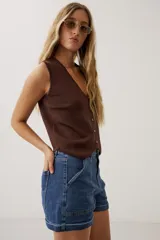 Short de denim azul de tiro medio, con bolsillos delanteros aplicados y dobladillo en las piernas.