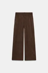 Pantalón de tiro alto con diseño de pierna ancha, confeccionado en tejido con efecto ante. Cuenta con cintura elástica y bolsillos laterales ocultos en la costura.