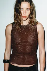 Top sin mangas, color azul marino, con cuello redondo y aplicación de brillos plateados que se dispersan desde el escote hacia el cuerpo.