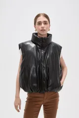 Chaleco puffer sin mangas confeccionado en cuero sintético negro, con cuello alto y cierre frontal.