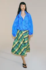 Falda midi de tiro medio marca ZWE Collection, confeccionada en hilatura de algodón con diseño de cuadros tipo tartán en tonos verdes, azules y amarillos. Tiene corte evasé y cierre lateral con cremallera oculta.