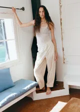 Pantalón de algodón color beige, de corte recto y silueta holgada. Cuenta con cintura elástica ajustable con cordón y detalles de bordado lateral.