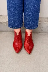 Zapatos abiertos en el talón modelo Eliana, con taco bloque de madera de 7,5 cm, punta fina y diseño lateral con abertura. Combinan diferentes texturas y tonos de cuero en color camel.