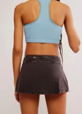 Short pollera deportivo color marrón con efecto lavado, cintura elástica y logo estampado en la parte delantera.