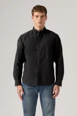 Camisa de manga larga color negro lavado, con cuello camisero con botones y cierre frontal abotonado.
