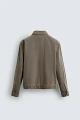 Sobrecamisa de denim de algodón negro con efecto lavado, corte relajado (relaxed fit). Presenta cuello solapa, cierre frontal con cremallera, manga larga con puño abotonado y bolsillo plastrón en el pecho.