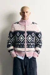Chaqueta de punto relaxed fit tejida con mezcla de lana, con diseño de rombos y patrones geométricos en tonos azul marino, blanco y rosado. Cuenta con cuello alto, manga larga, acabados en rib y cierre frontal con cremallera de doble dirección.