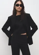 Pantalón negro de corte recto y tiro medio, confeccionado en poliéster.