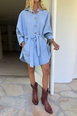 Vestido camisero blanco de algodón, corte holgado, con botones de madera, cuello clásico y lazo en la cintura.