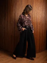 Blusa de gasa con estampado abstracto en tonos oscuros, cuello redondo con lazo ajustable, corte holgado con frunces y mangas largas abullonadas con puños elásticos.