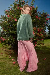 Sweater de lana verde tejido y bordado a mano con cuello a la base y puños. Presenta bordados de peces de colores en el frente. De calce holgado.