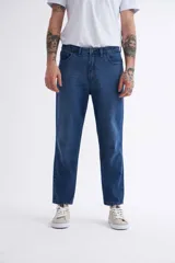 Jean azul oscuro de corte recto, tiro medio y largo a la altura del tobillo.