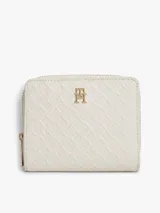 Billetera compacta Tommy Hilfiger color beige, con textura y monograma TH en bajo relieve. Cuenta con cierre de cremallera y detalle metálico del monograma en la parte frontal.
