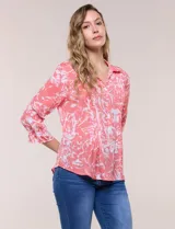 Blusa estampada en tonos rosado y blanco con diseño pincelado, de estilo romántico-casual y silueta semi holgada. Presenta escote en V con cuello solapa, media abotonadura frontal con botones nacarados, y finas alforzas verticales en la pechera. Las mangas son tres cuartos con puños elastizados en punto smock y terminación fruncida, y el ruedo es curvo con largo a la cadera.