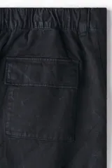 Pantalón cargo de sarga de algodón con corte relajado, cierre de botón y cremallera, bolsillos laterales tipo cargo con solapa y botones a presión ocultos.