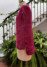 Chaleco tejido a mano en dos agujas con hilado 100% baby alpaca teñido artesanalmente, color magenta matizado. Diseño ligeramente oversize, de hombros anchos y cuello tipo bote, con puntos calados en frente y espalda y tajos a los lados en el bajo.