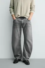 Jeans de denim de algodón en color negro con efecto lavado, corte amplio y silueta curva tipo barrel fit con pinzas en las rodillas. Presenta diseño clásico de cinco bolsillos y cierre frontal con cremallera y botón metálico.