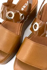 Sandalia de cuero color marrón con plataforma y ajuste con hebilla.