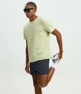Bermuda deportiva de running para hombre en microfibra color beige, con cintura elástica, cordón ajustable y bolsillos laterales.