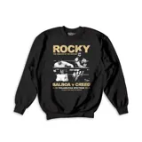 Buzo de cuello redondo y manga larga en color negro, con estampa frontal cinematográfica de la película Rocky, representando el combate entre Balboa y Creed.