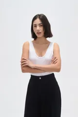 Body de poliamida al cuerpo con breteles anchos, cuello profundo y cierre con broches en la parte inferior.