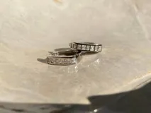 Par de aros tipo argolla de plata 925 con acabado en oro de 18k, adornados con circonias cúbicas.