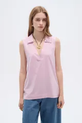 Musculosa de algodón color rosado, con cuello en V y cuello polo, sin mangas y diseño holgado.
