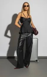 Pantalón negro de cuero sintético con corte palazzo y bolsillos laterales tipo cargo.