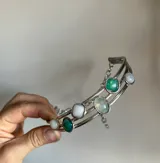 Gargantilla plateada de tres hilos con piedras redondas y cuadradas de color blanco, verde y celeste.