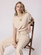 Pantalón color beige de corte holgado con cintura elastizada y cordón ajustable.