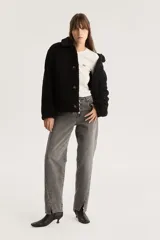 Campera negra de sherpa con cuello camisero, cierre con botones a presión y calce estándar.