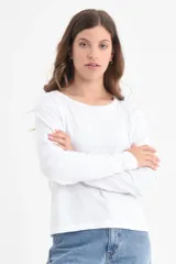 Camiseta básica de manga larga en color blanco, con cuello redondo y confeccionada en algodón orgánico.