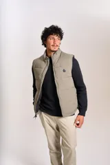 Chaleco puffer de corte regular, color beige, con cierre frontal y cuello alto. Presenta un diseño acolchado horizontal y logo bordado en el pecho.