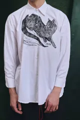 Camisa blanca de algodón con cuello clásico, manga larga con puños abotonados y estampado frontal de un animal similar a un zorro.