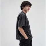 Remera oversize de algodón con acabado stonewash y efecto desgastado, con logo ovalado retro estampado en la espalda.