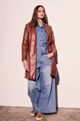 Trench marrón de cuero vegano, corte al cuerpo y largo hasta la rodilla.